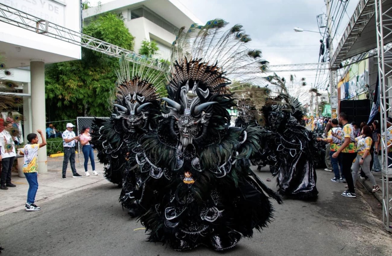 Los Warriors Carnaval group in feathered costumes parading at Carnaval Vegano in La Vega, Dominican Republic